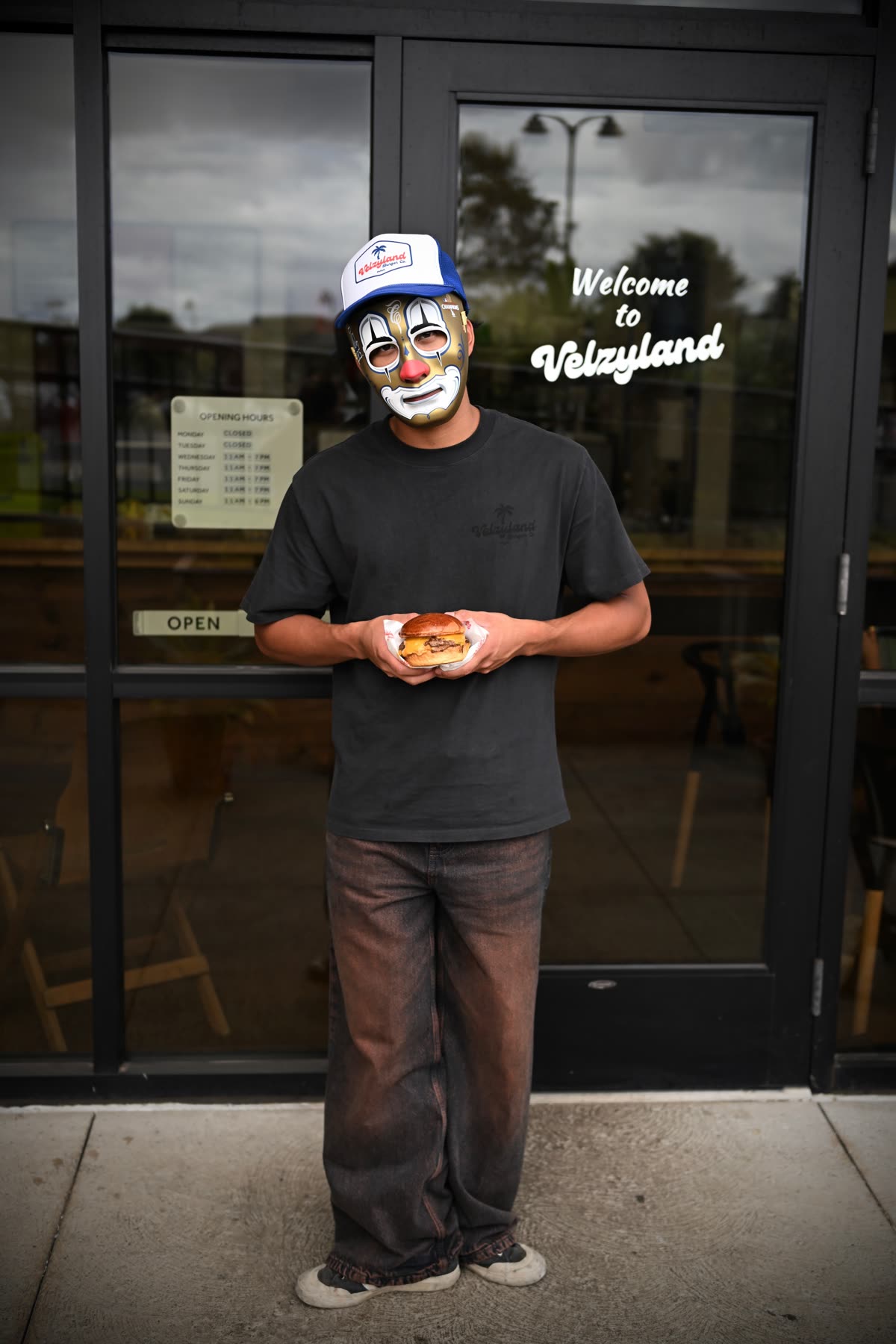 Regular in a mask holding a Velzy Burger